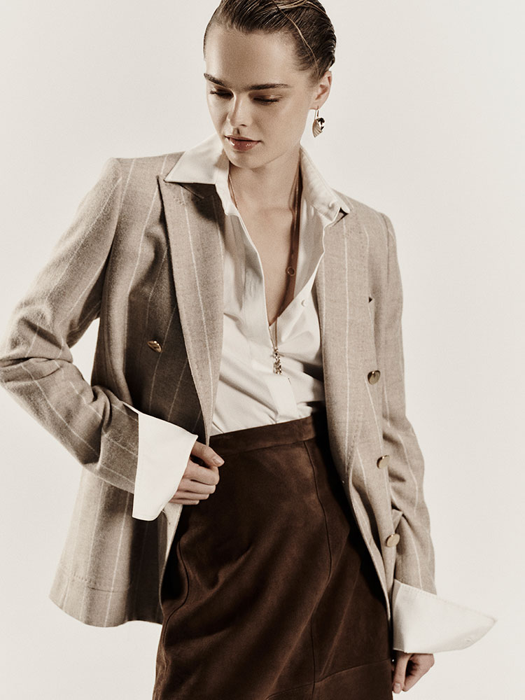 Model wears beige Max Mara Sartoriale alpaca and wool double-breasted blazer, with light shirt and brown trousers.